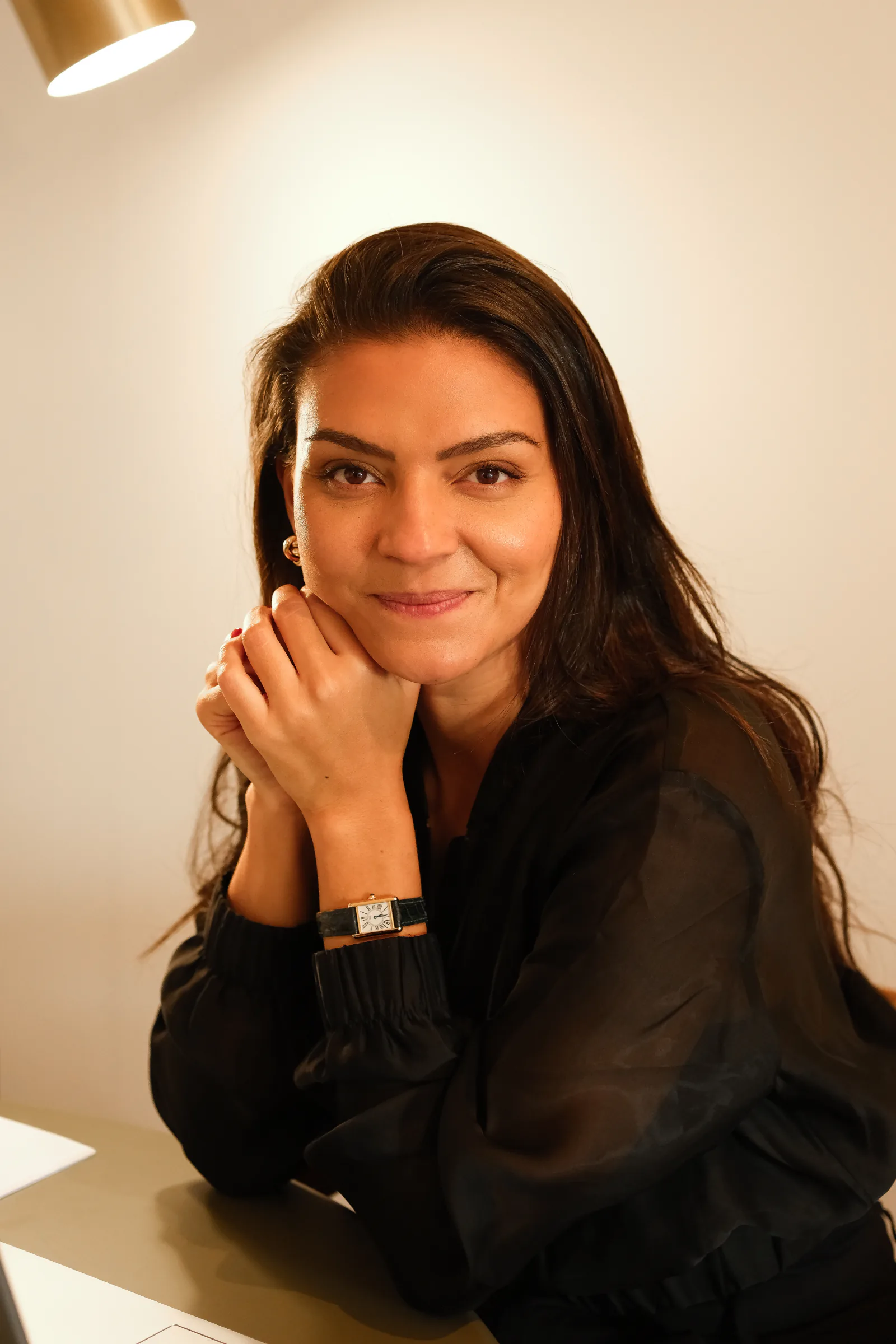 Bárbara, advogada, sentada à secretária e a olhar para a câmara